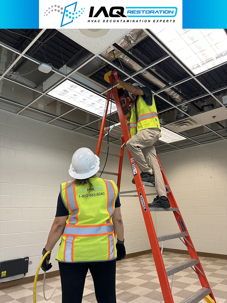 IAQ Restoration technicians accessing ceiling ductwork in a commercial facility