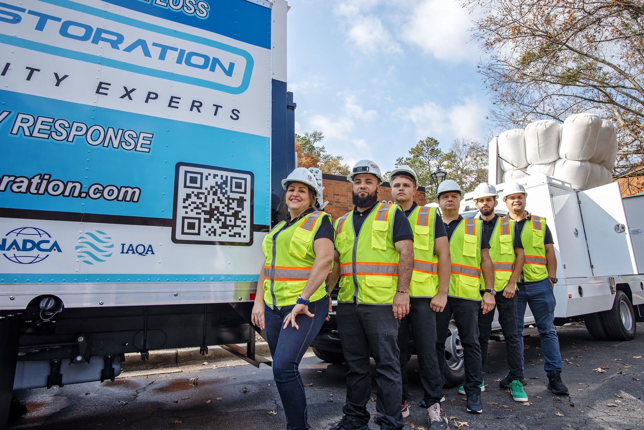 IAQ Restoration NADCA-certified duct cleaning crew beside a branded response truck